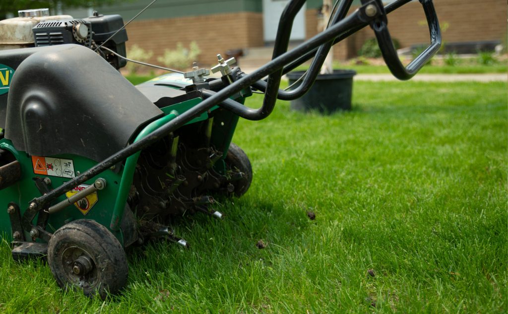 aerating yard with machine for fall lawn maintenance