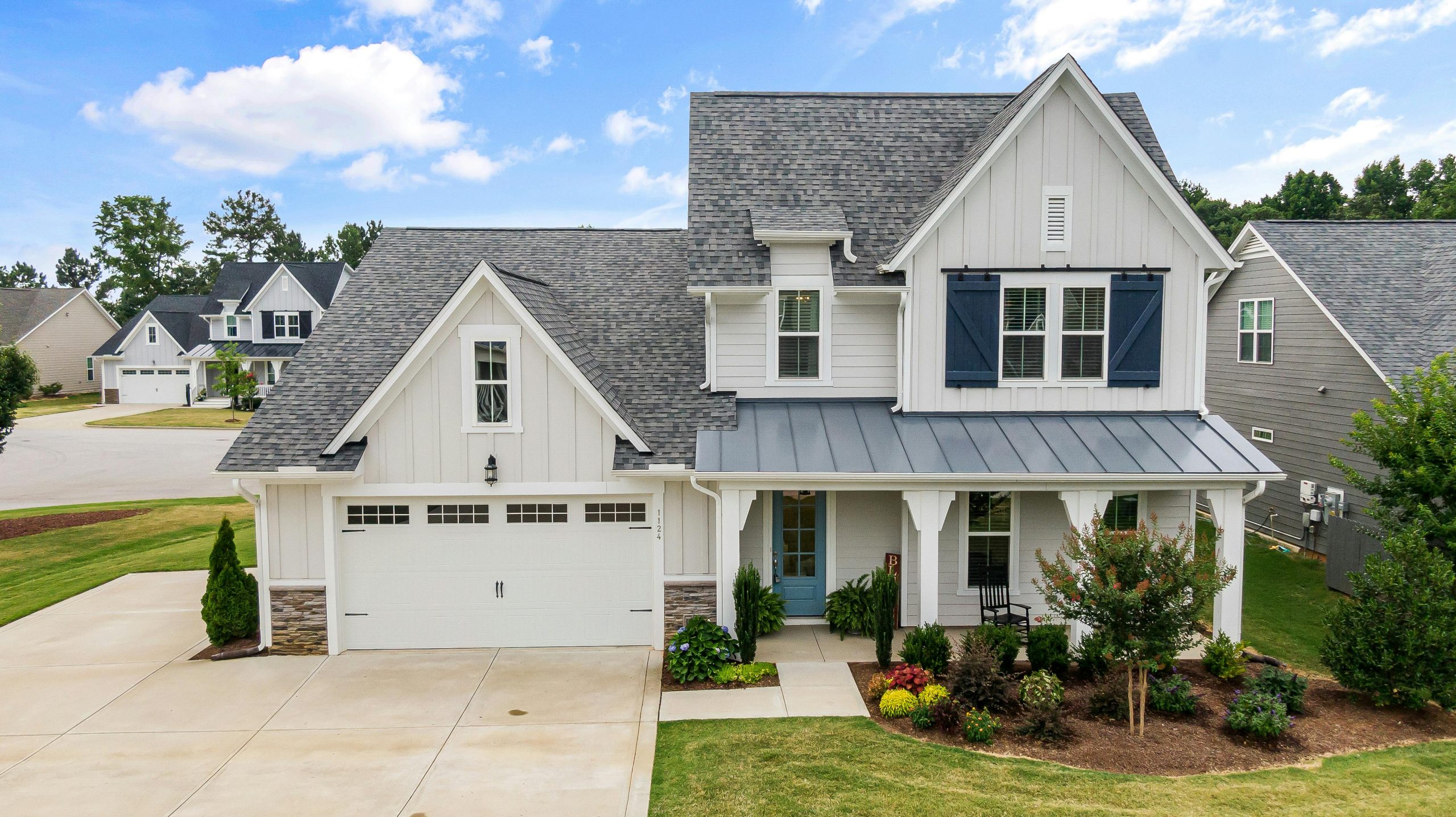 A beautifully landscaped front yard with red and deep green shrubs