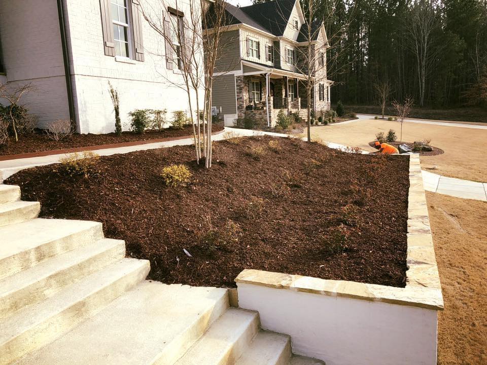 Dark hardwood mulch installed in a raised flowerbed in front of home.